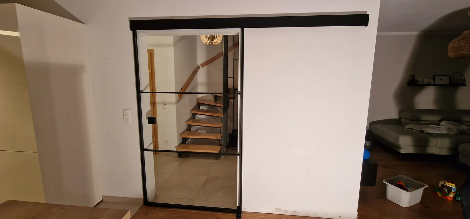 Schiebetür zwischen Wohnbereich und Treppe, halb geöffnet